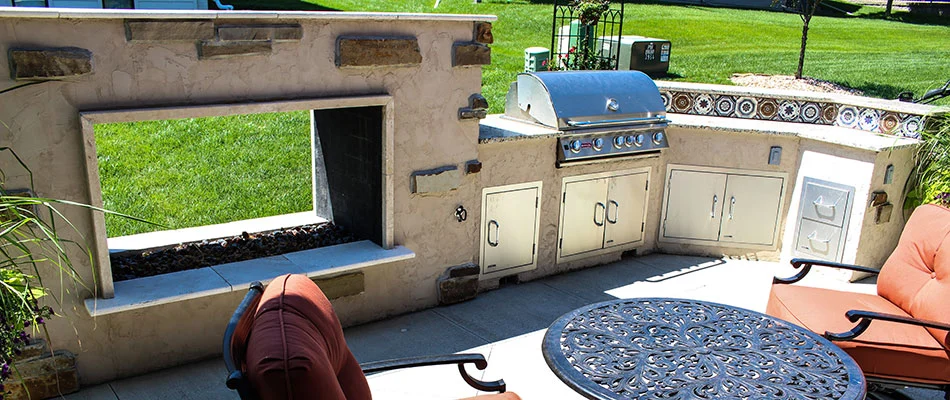 A fire trough installed alongside an outdoor kitchen in Omaha, NE.