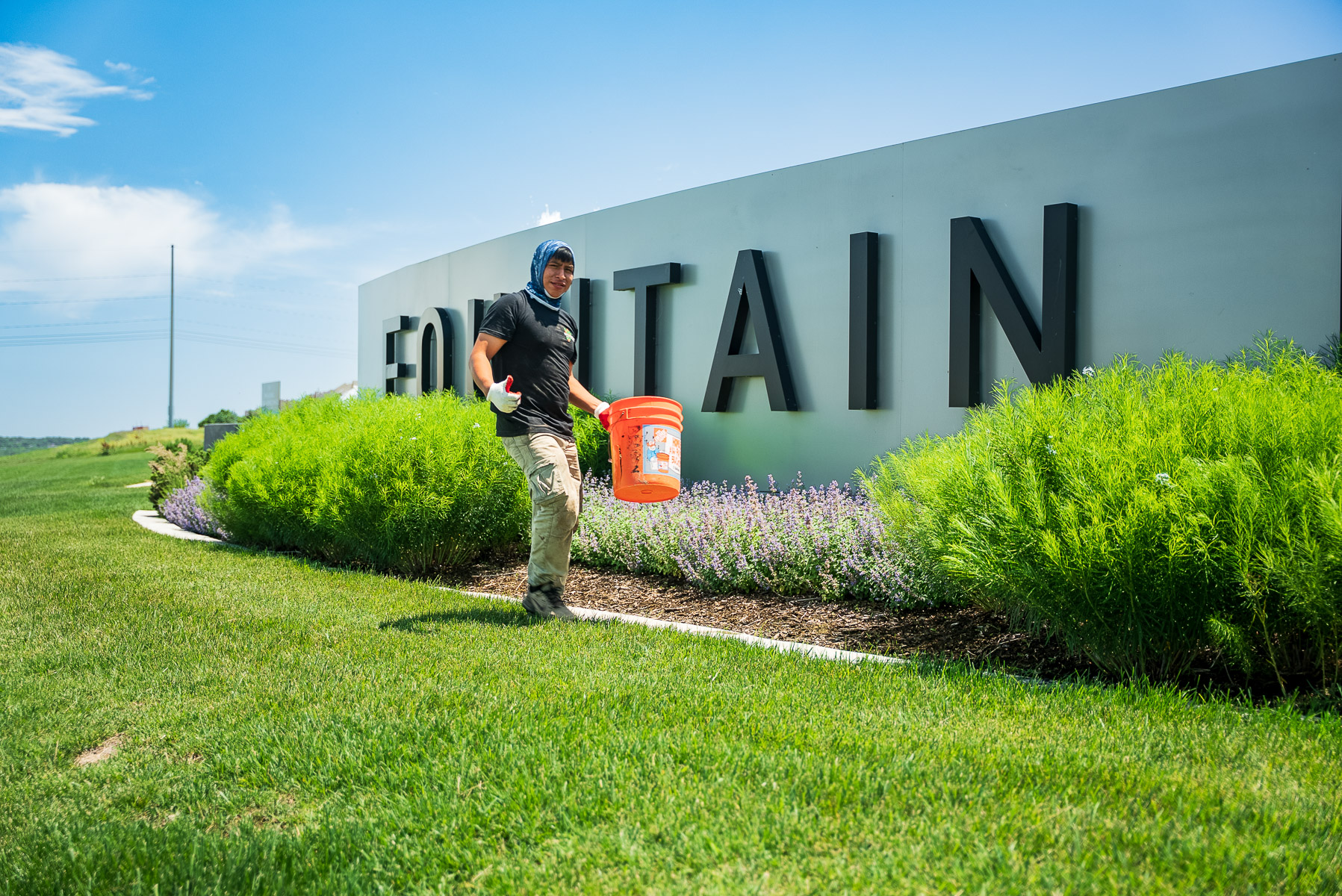 commercial maintenance crew hand pulling weed planting bed happy