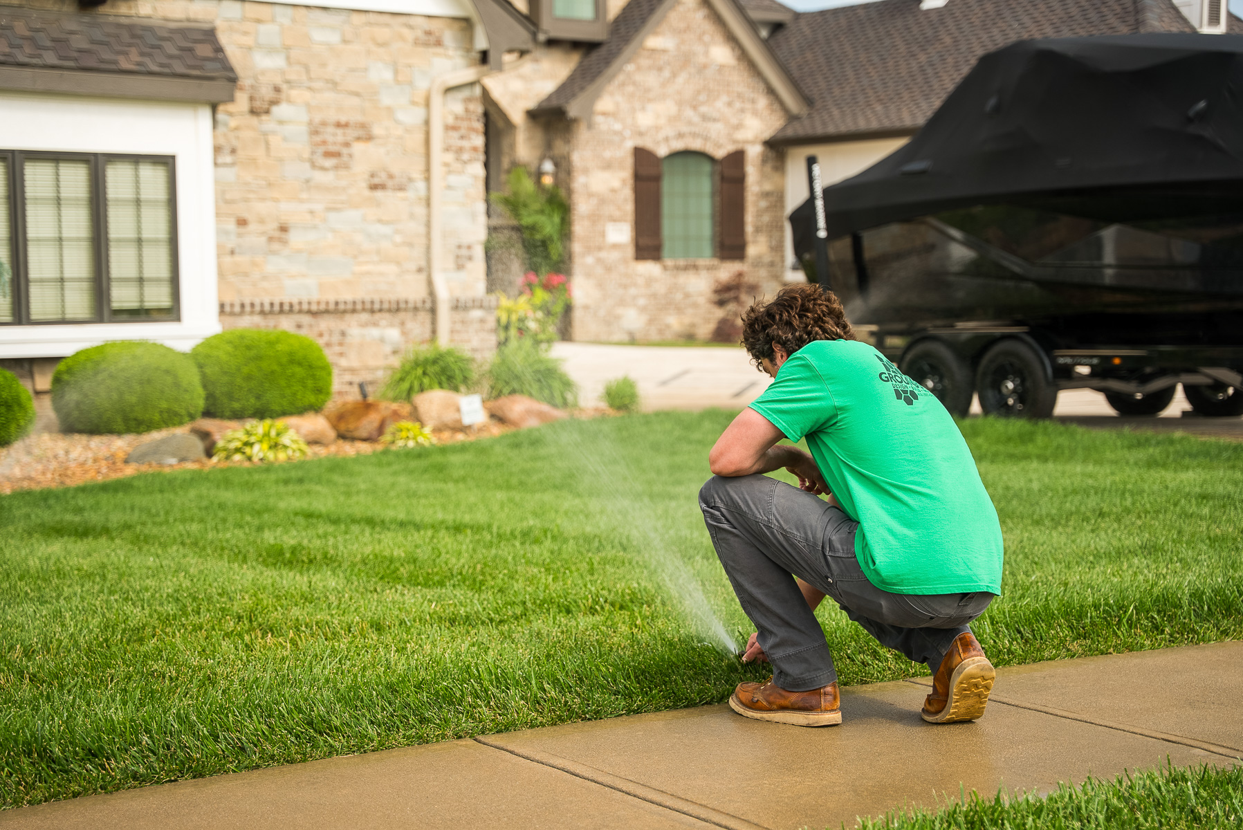 irrigation tech adjusting sprinkler nozzle spray inspection