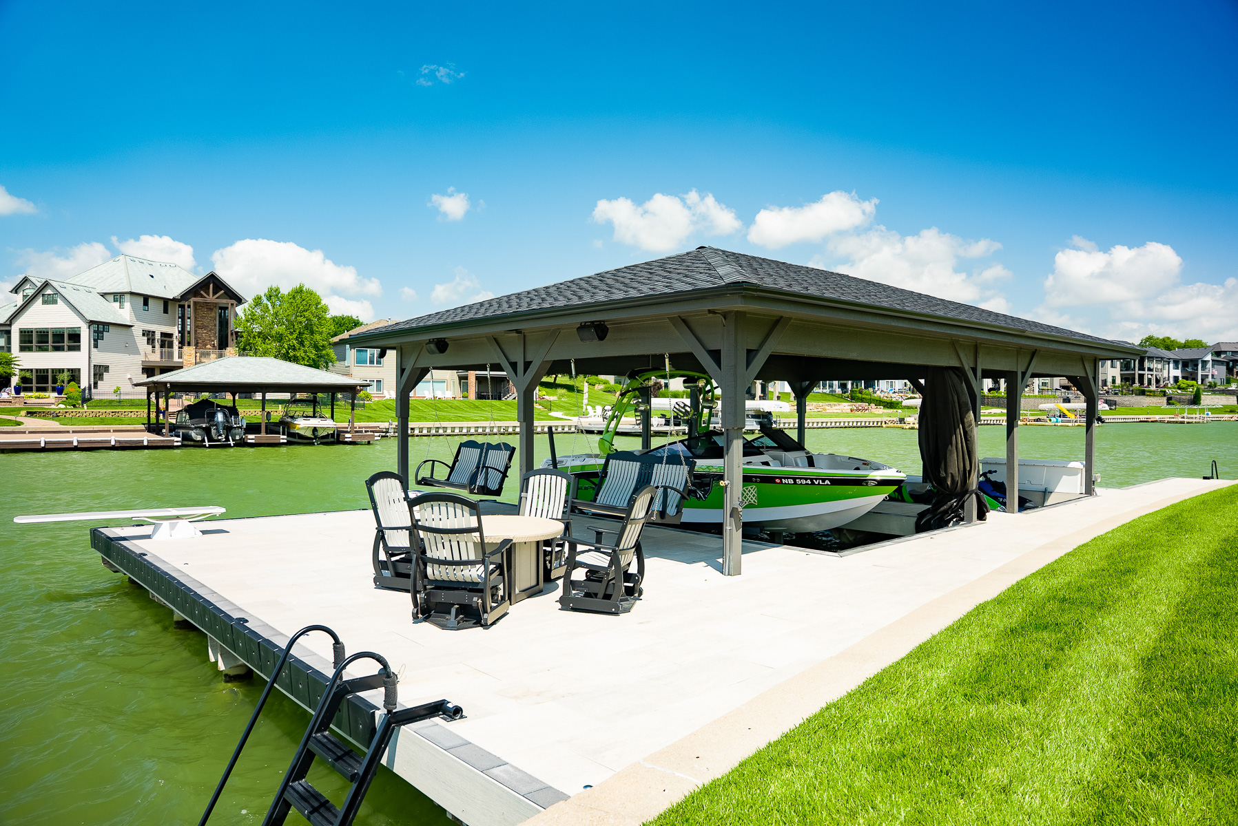 marine dock lake front boat grass lawn table chairs steps ladder swing