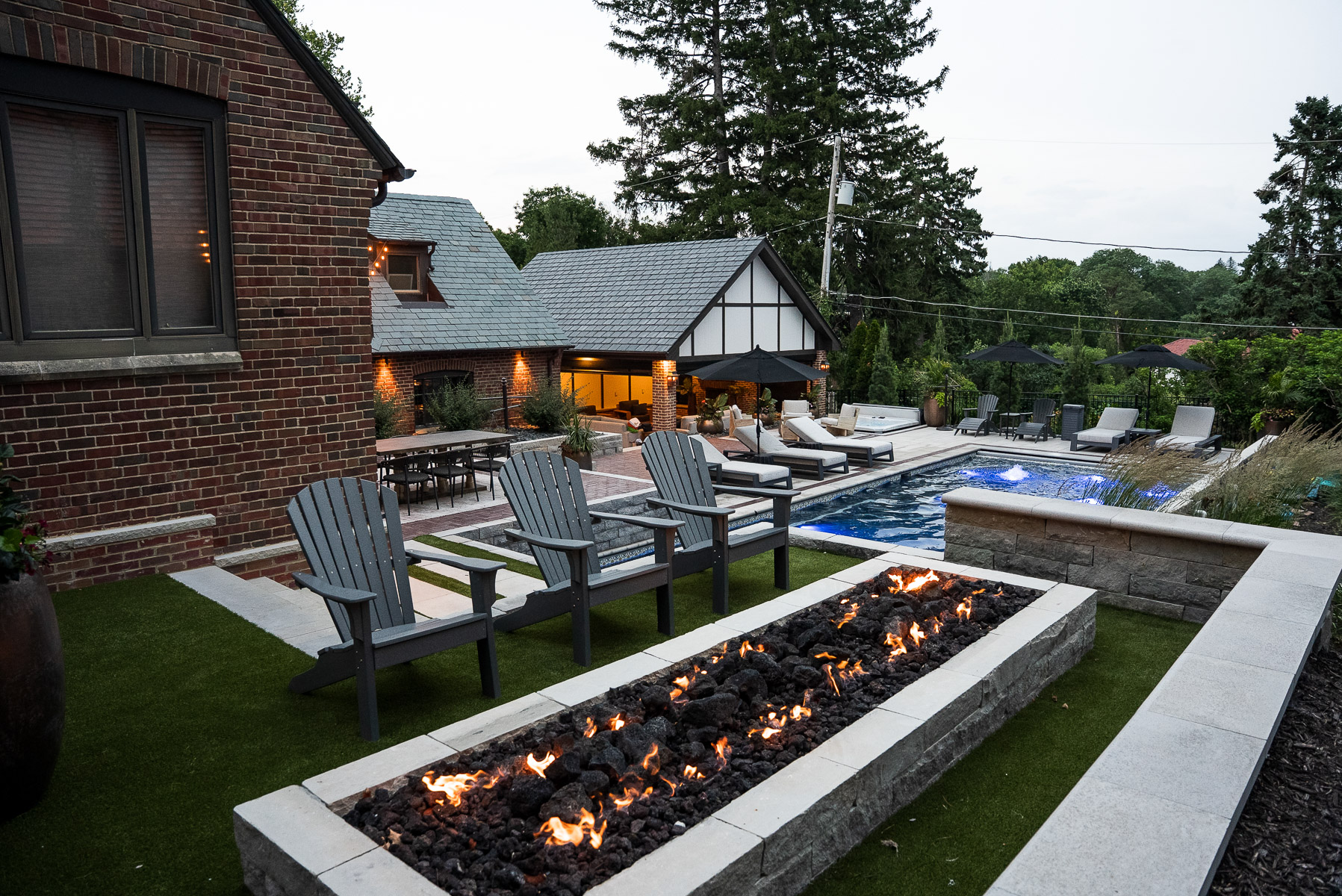 nice backyard firepit stone wall seating pool pergola lighting 2