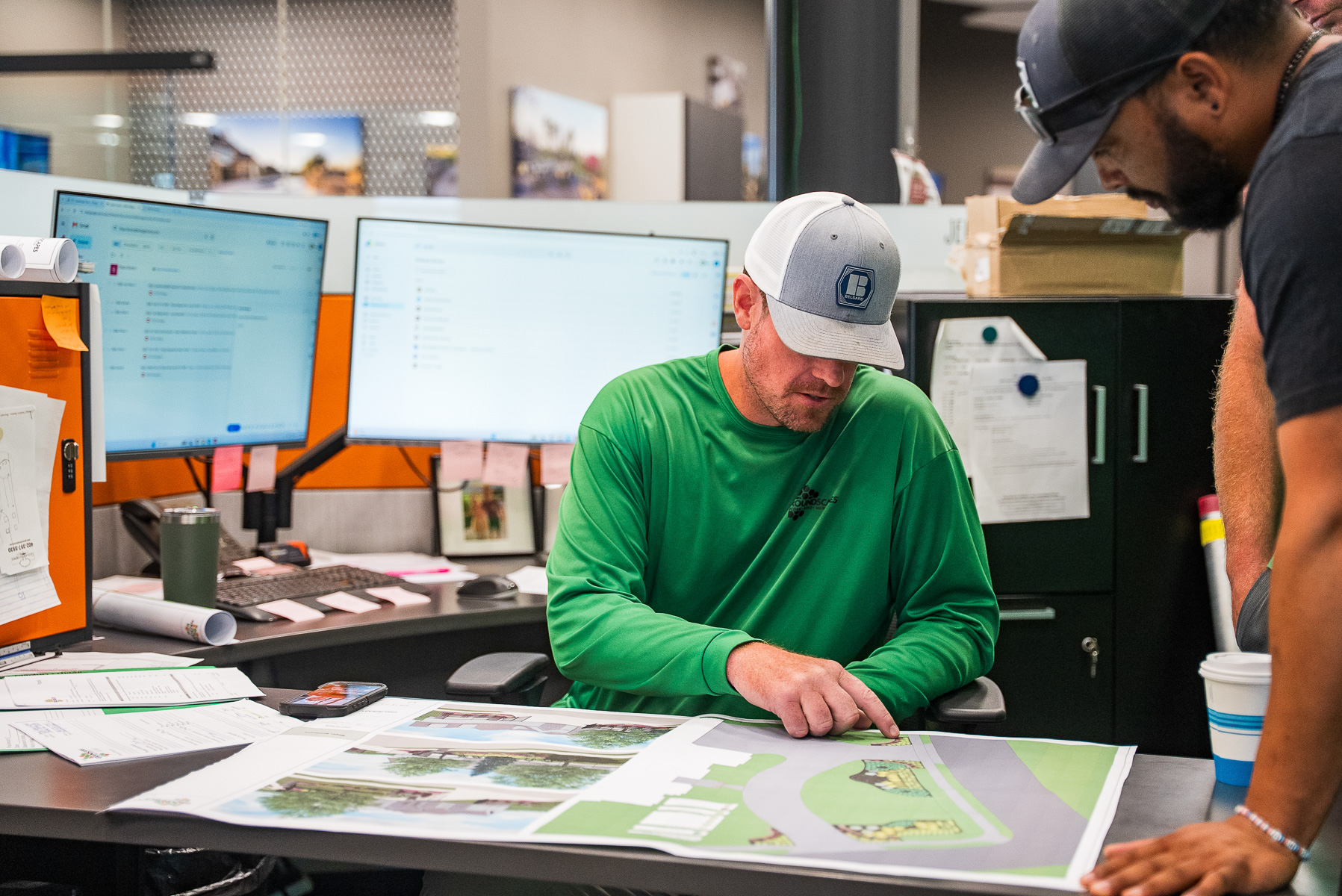 office staff landscape designer review plans crew