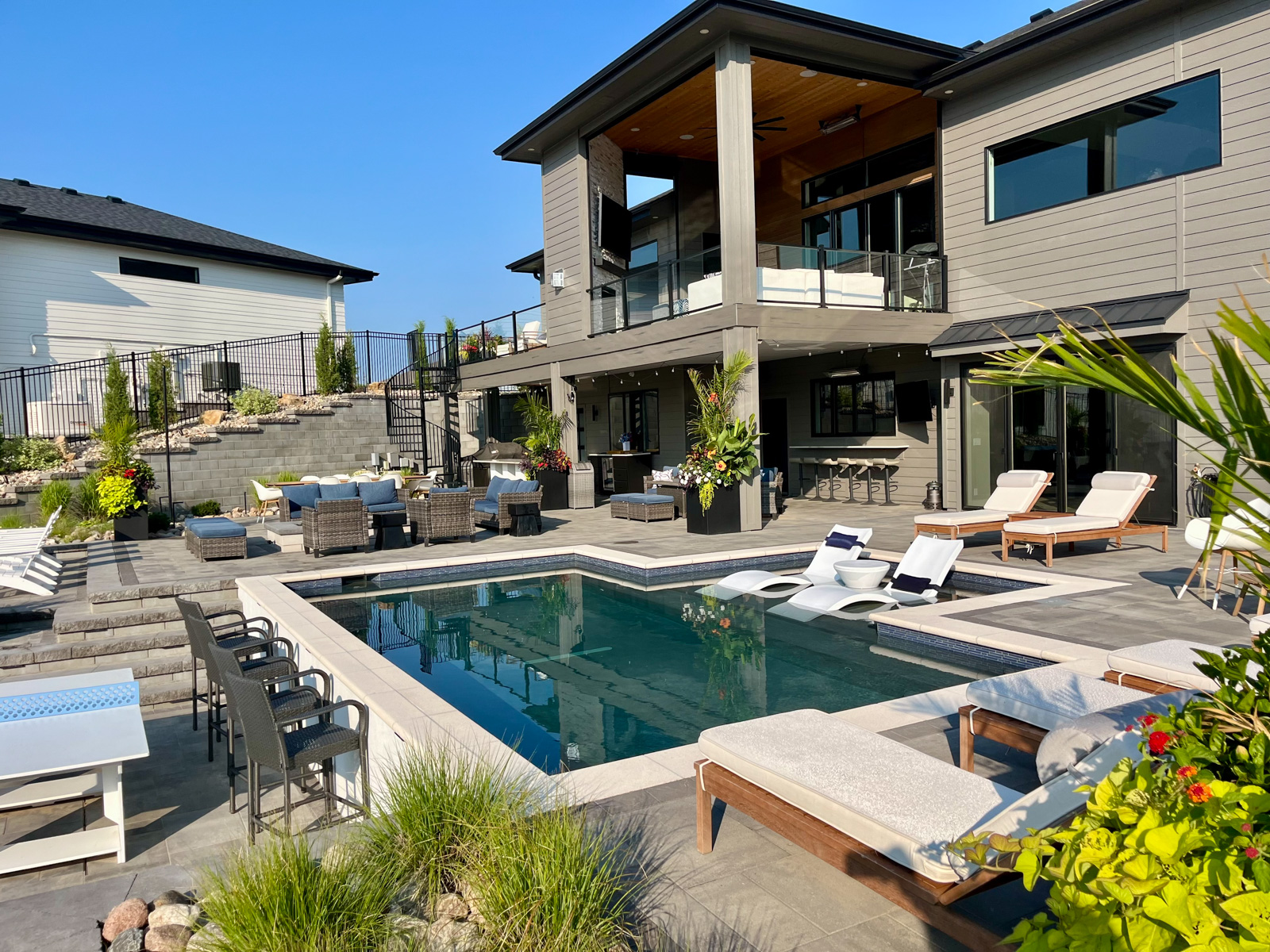backyard pool tanning ledge seating stone deck counter bar chairs spiral staircase